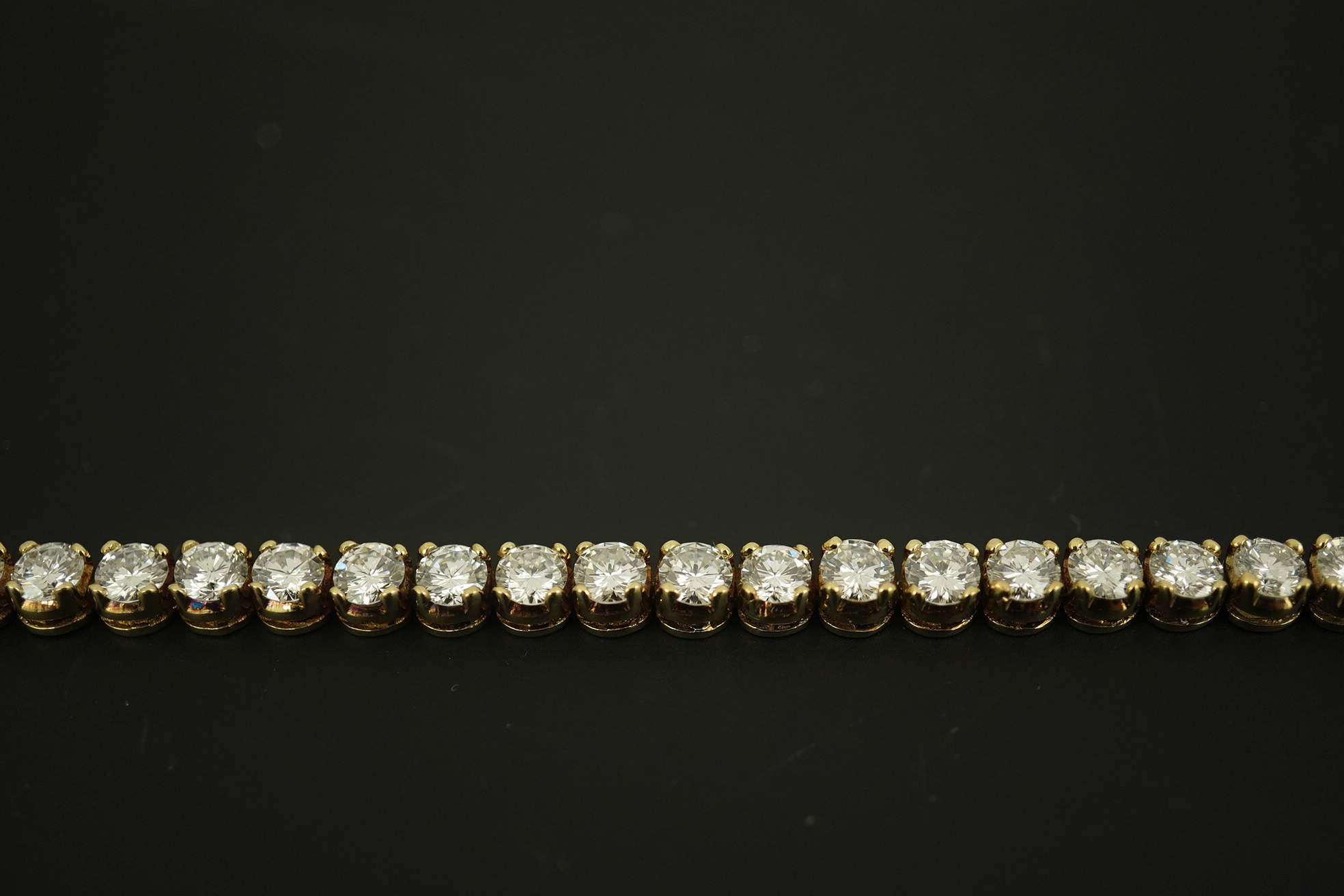 A modern 14k gold and thirty five stone round brilliant cut diamond set tennis bracelet